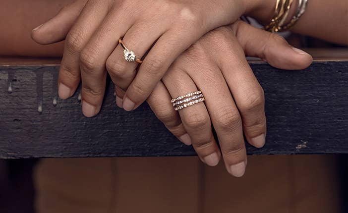 Woman hands crossed over wearing multiple rings