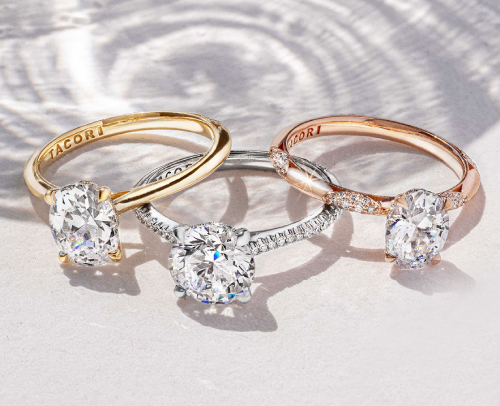 assortment of three engagement rings in platinum, rose gold and yellow gold